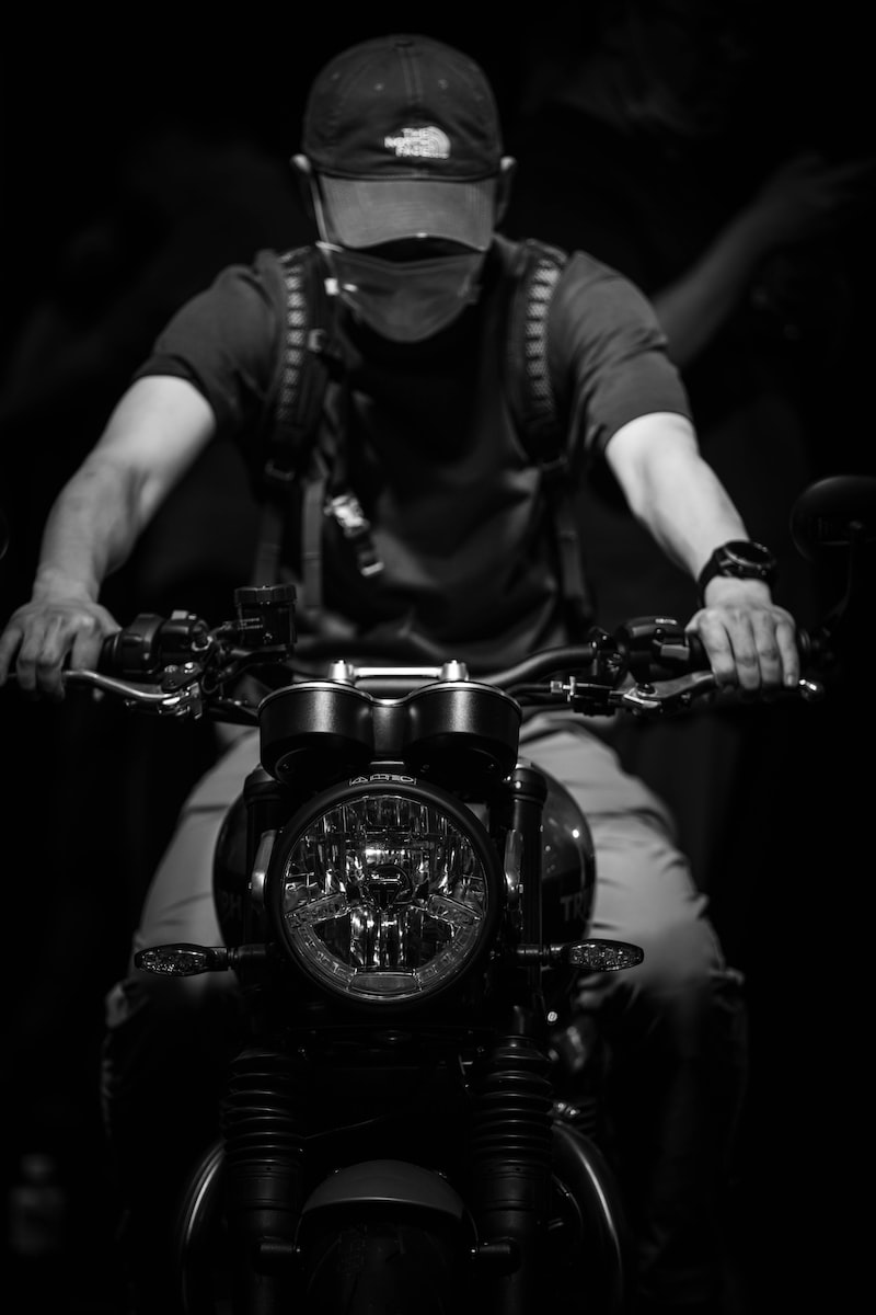 man in black vest riding motorcycle