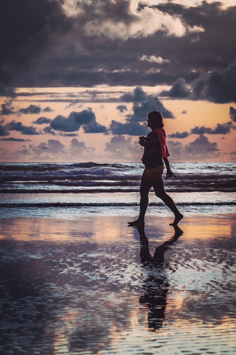 woman walking on shore during daytime